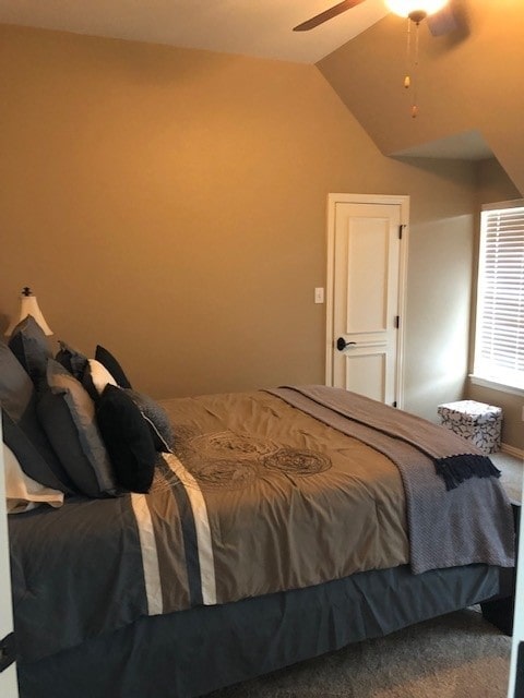 bedroom featuring carpet floors, vaulted ceiling, and a ceiling fan