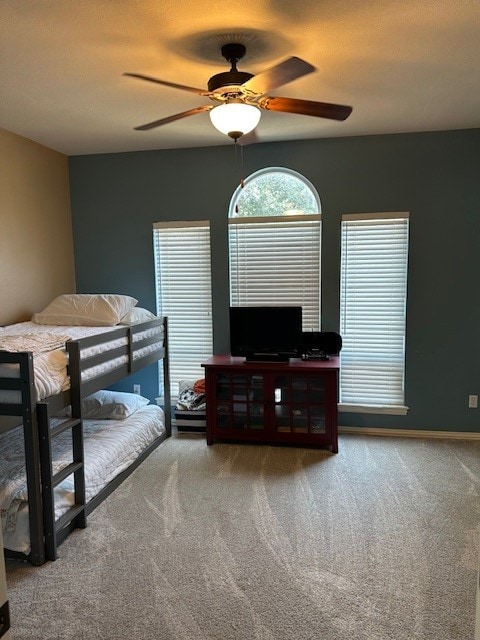 carpeted bedroom with a textured ceiling, a ceiling fan, and baseboards