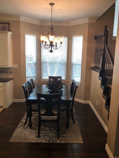 dining room featuring an inviting chandelier, baseboards, ornamental molding, and dark wood-style flooring