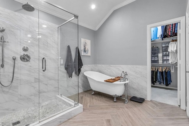 bathroom with ornamental molding, a stall shower, a freestanding tub, and a spacious closet