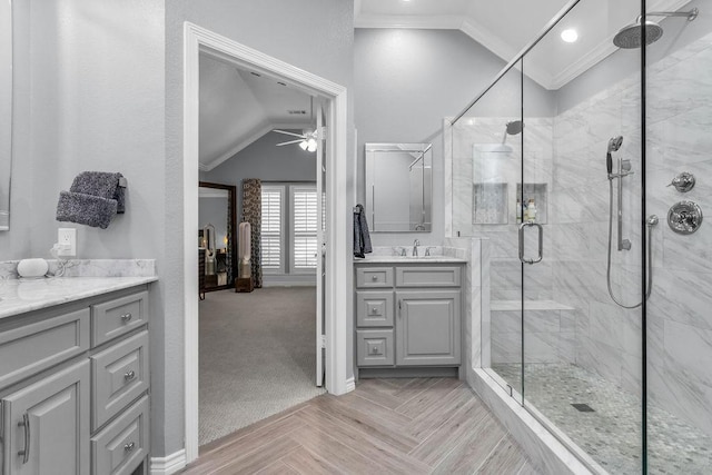 full bath featuring lofted ceiling, ornamental molding, a stall shower, vanity, and baseboards