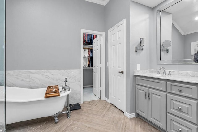 bathroom with crown molding, vanity, and a freestanding bath