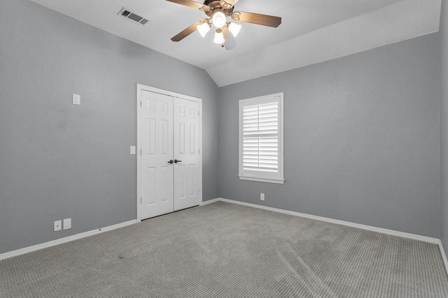 interior space with baseboards, visible vents, lofted ceiling, carpet floors, and a closet