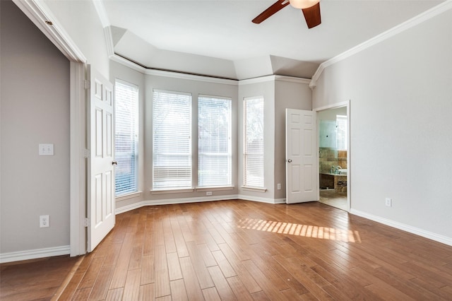 spare room featuring ornamental molding, ceiling fan, baseboards, and wood finished floors