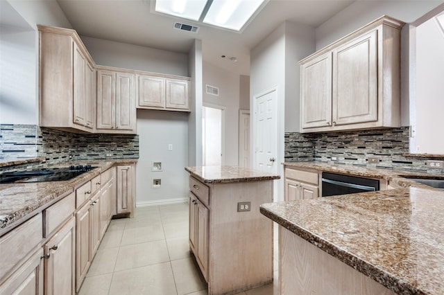 kitchen featuring light stone countertops, visible vents, and a center island