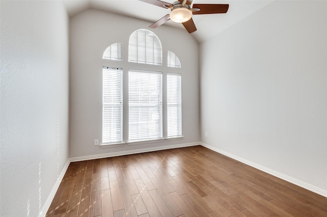 empty room featuring baseboards, a ceiling fan, vaulted ceiling, and wood finished floors