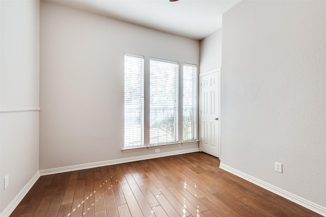 unfurnished room featuring wood-type flooring and baseboards