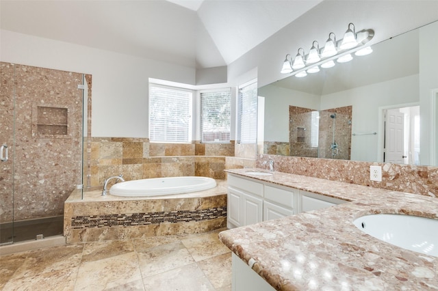 full bath with a bath, a shower stall, double vanity, and a sink