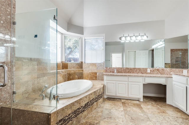 bathroom with vaulted ceiling, vanity, a shower stall, and a bath