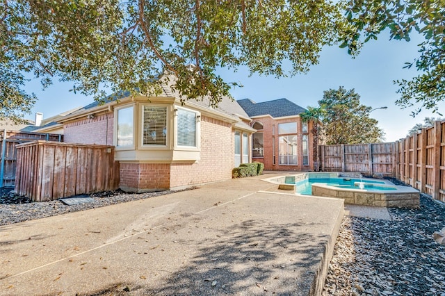 view of pool featuring a fenced backyard, a patio, and an in ground hot tub