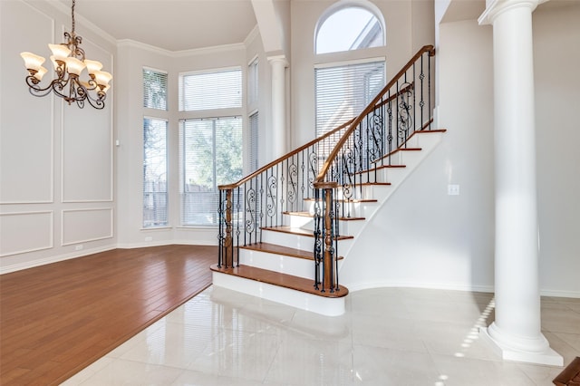 entrance foyer featuring ornamental molding, decorative columns, and wood finished floors