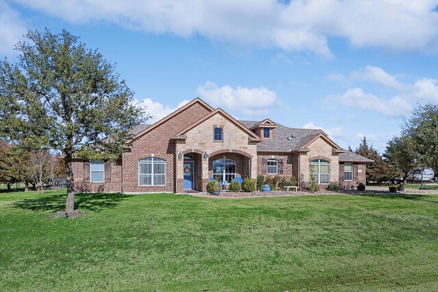 7910 Stone Ridge Dr, Northlake, TX 76247 - french country inspired facade with brick siding, a front lawn, and stone siding