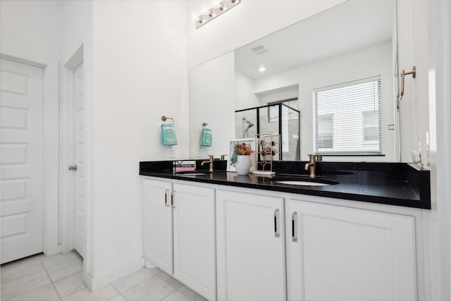 full bath featuring a stall shower, a sink, baseboards, and double vanity