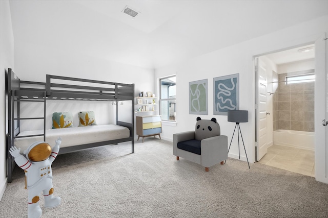 carpeted bedroom featuring ensuite bath, multiple windows, visible vents, and baseboards