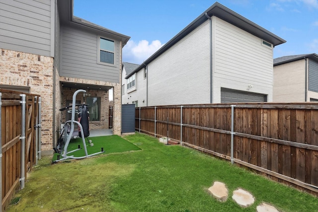 view of yard with a garage and a fenced backyard