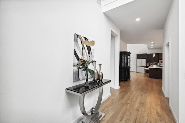 hallway featuring light wood-style floors, recessed lighting, and baseboards