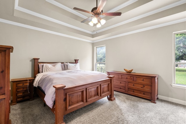 bedroom with a tray ceiling, crown molding, light carpet, ceiling fan, and baseboards