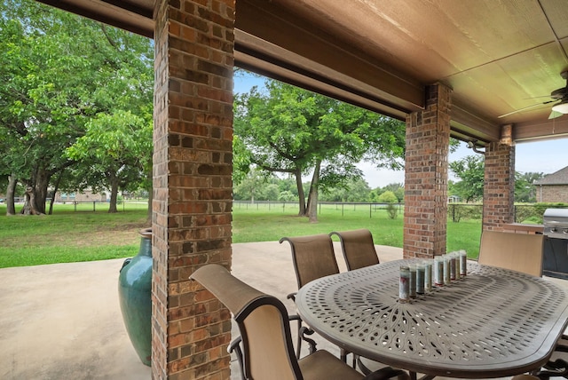 view of patio with outdoor dining space, fence, and ceiling fan