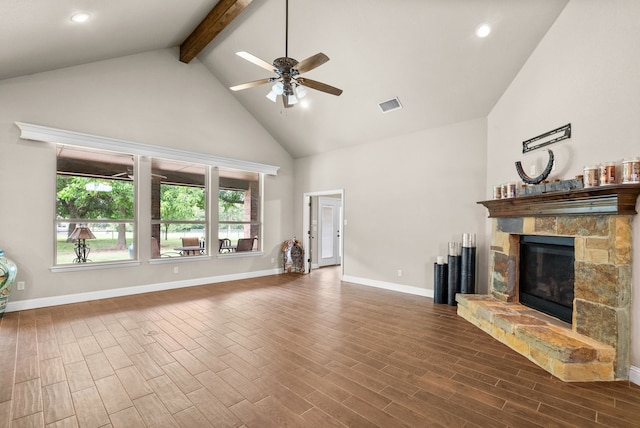 unfurnished living room featuring baseboards, visible vents, dark wood finished floors, a stone fireplace, and beam ceiling