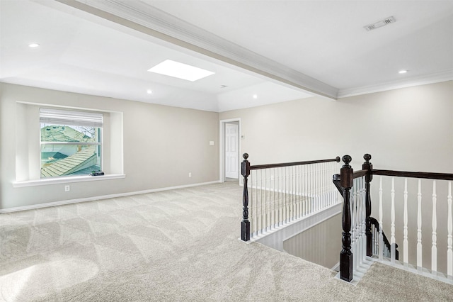 empty room featuring a skylight, baseboards, crown molding, carpet floors, and recessed lighting