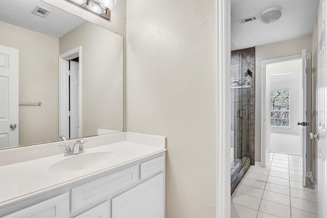 bathroom featuring tile patterned floors, a shower stall, visible vents, and vanity