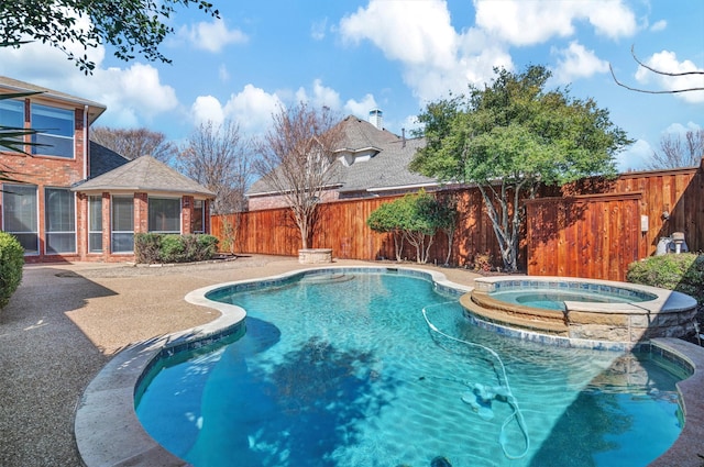 view of swimming pool featuring a patio area, a pool with connected hot tub, and a fenced backyard