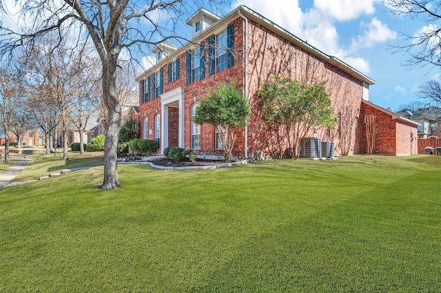 view of side of property with brick siding and a yard