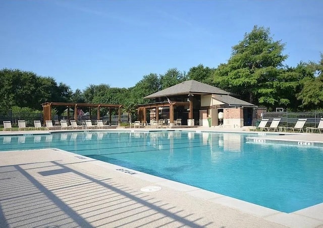 pool with a patio area, fence, and a pergola