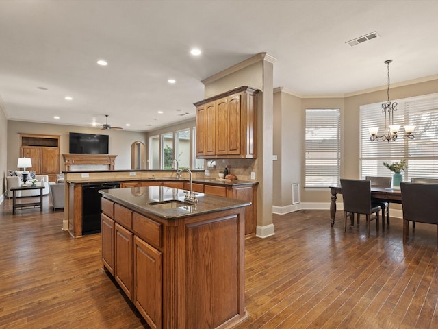 kitchen with black dishwasher, dark wood-style flooring, a center island with sink, visible vents, and brown cabinetry