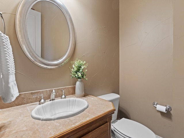 half bathroom featuring vanity and toilet