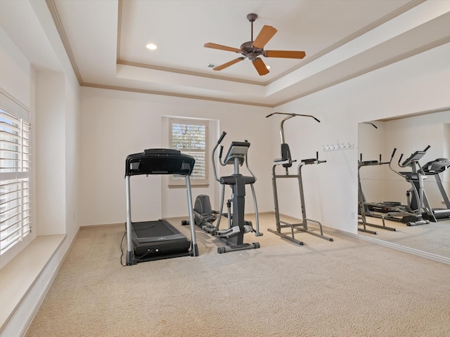 exercise room featuring carpet floors, a tray ceiling, crown molding, recessed lighting, and ceiling fan