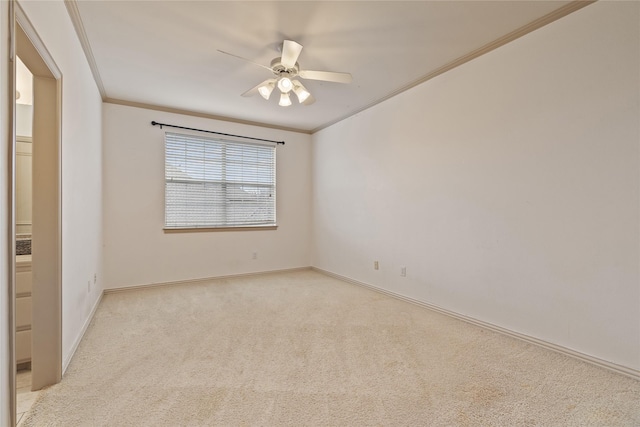 unfurnished room featuring light carpet, ornamental molding, a ceiling fan, and baseboards