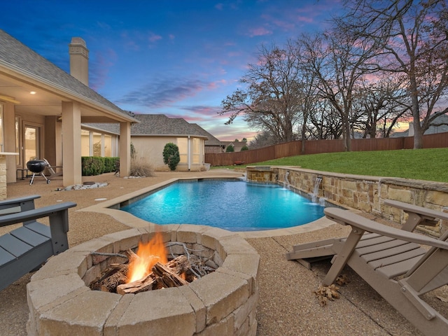 pool at dusk featuring a patio area, a fenced backyard, a fire pit, and a fenced in pool