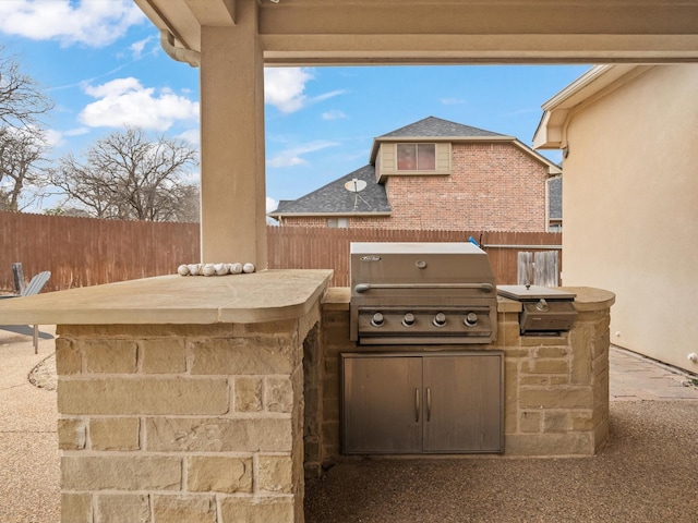 view of patio featuring exterior kitchen, fence, and area for grilling