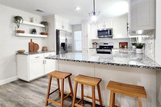 kitchen featuring open shelves, visible vents, stainless steel appliances, and backsplash