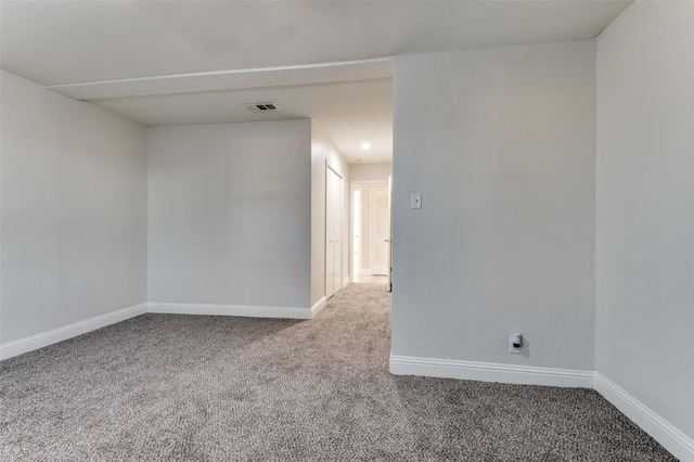 unfurnished room with carpet, visible vents, and baseboards