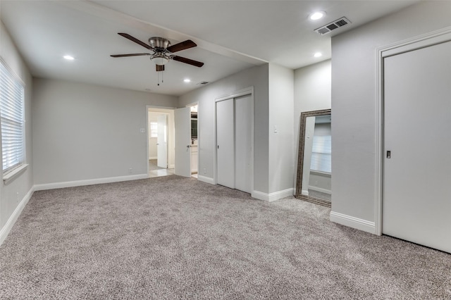 unfurnished bedroom featuring recessed lighting, visible vents, baseboards, carpet, and two closets