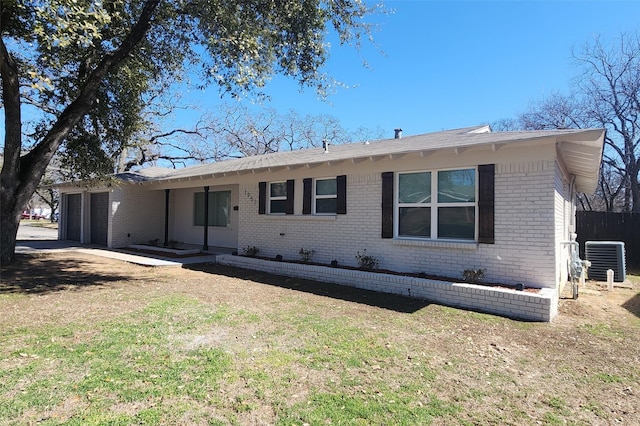 single story home featuring a front lawn, brick siding, an attached garage, and central AC unit