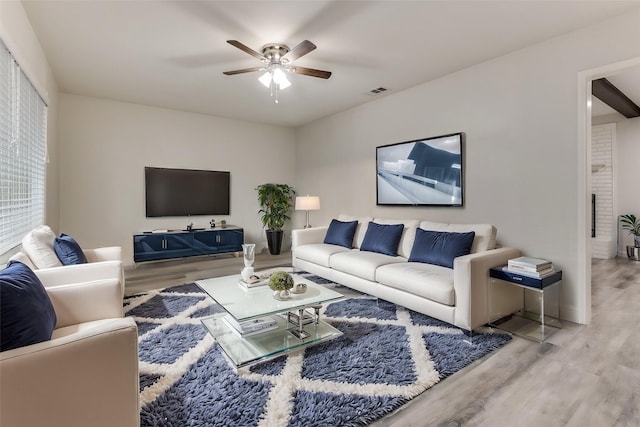 living room featuring visible vents, a ceiling fan, and wood finished floors