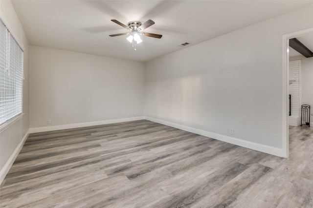 unfurnished room with ceiling fan, baseboards, and wood finished floors