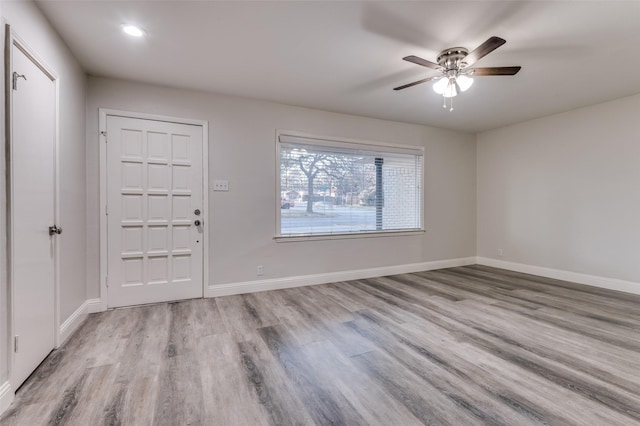 foyer featuring a ceiling fan, baseboards, and wood finished floors