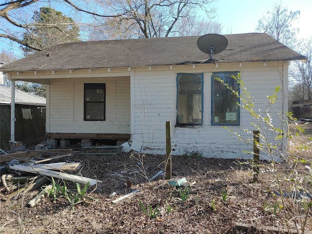 view of side of home featuring roof with shingles