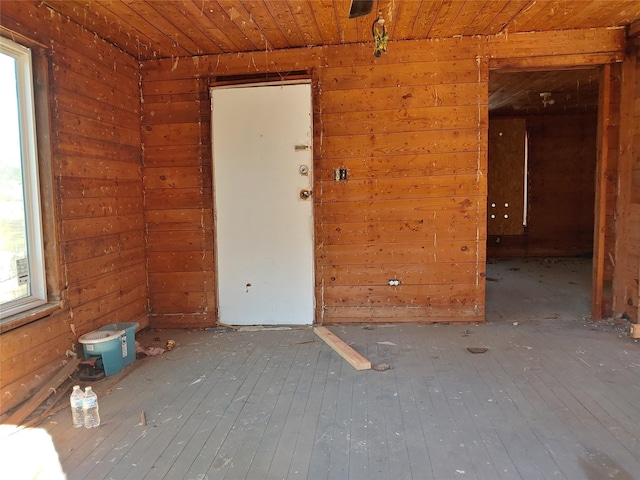 spare room with wooden ceiling, wood-type flooring, and wood walls