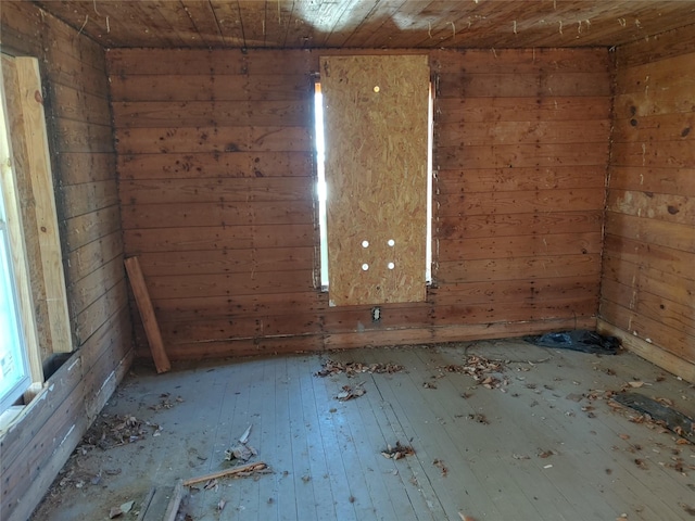 spare room featuring wood ceiling and wood walls