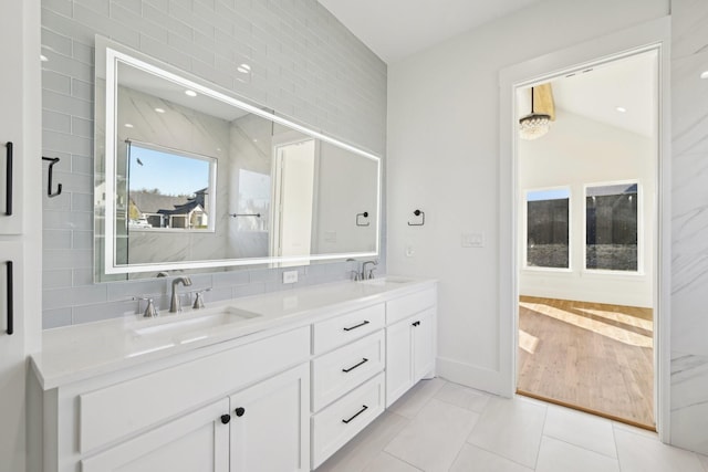 full bathroom with tile patterned flooring, a sink, and double vanity