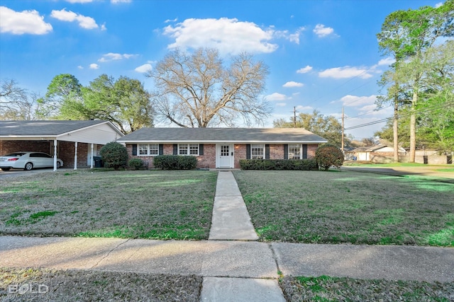 view of front of home featuring a front lawn, an attached carport, and brick siding