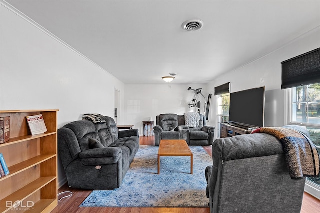 living area with visible vents, plenty of natural light, and wood finished floors