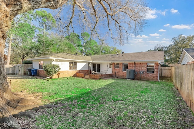 back of house featuring central air condition unit, a yard, a fenced backyard, and brick siding