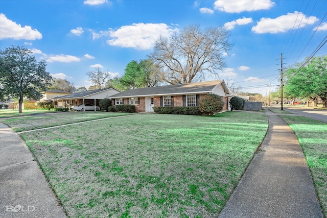 ranch-style house featuring a carport, a front yard, and brick siding