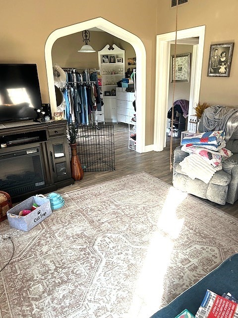 interior space featuring arched walkways, wood finished floors, and visible vents